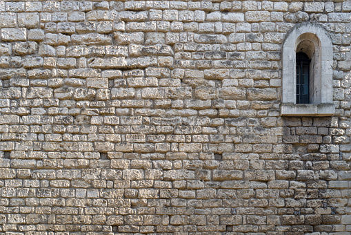 Old stone wall background with arched window. Textured backdrop will space for text.