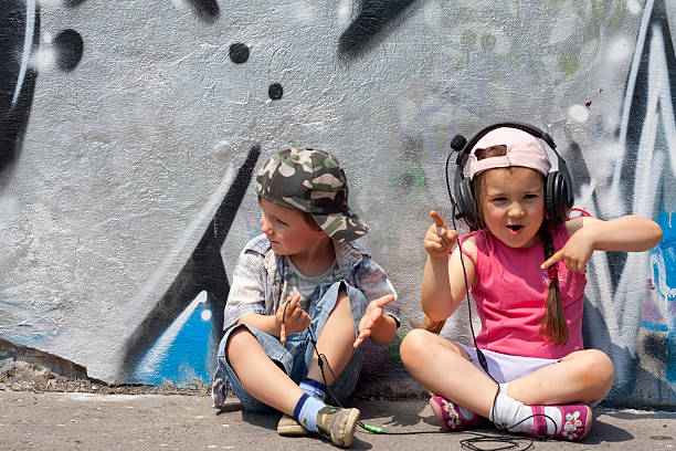 Child boy breakdancing during street party with her friends outdoors