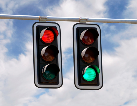 Red and green traffic lights against blue sky backgrounds