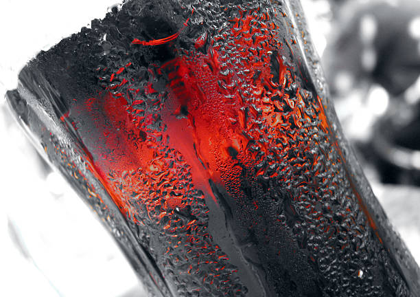 Stockholm, Sweden - June 24, 2011: Coca Cola bottle cap on red and wet surface. Studio shot.
