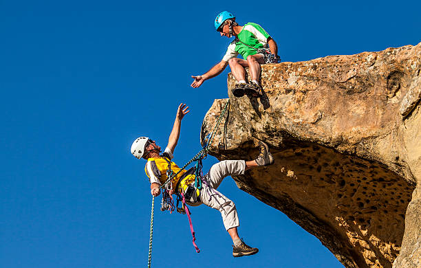 Climbing team struggles to the summit. stock photo