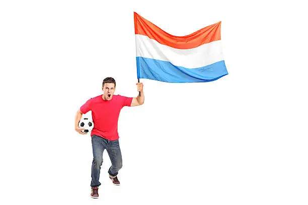 Photo of Male euphoric fan holding a football and dutch flag
