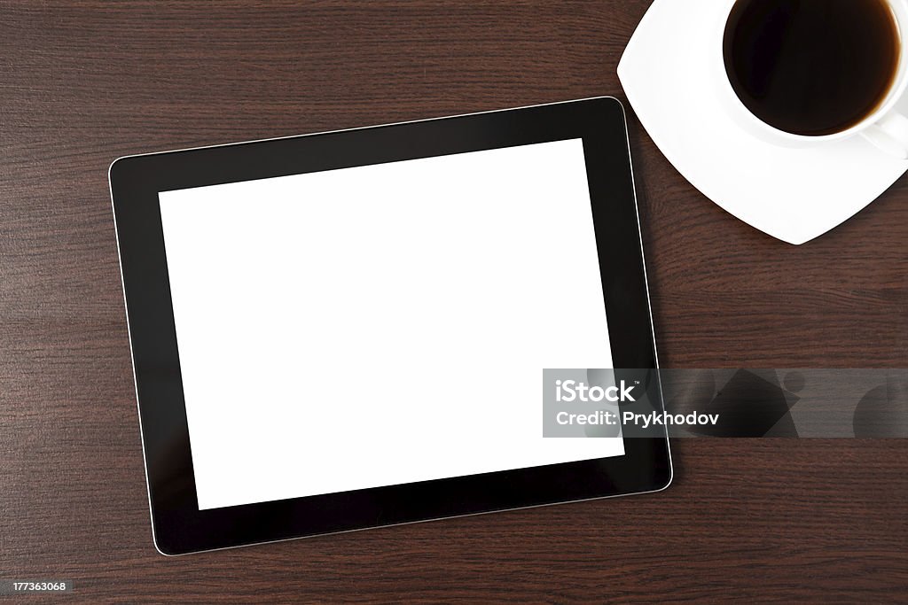 Un tablet e un cap di caffè sul tavolo - Foto stock royalty-free di Affari