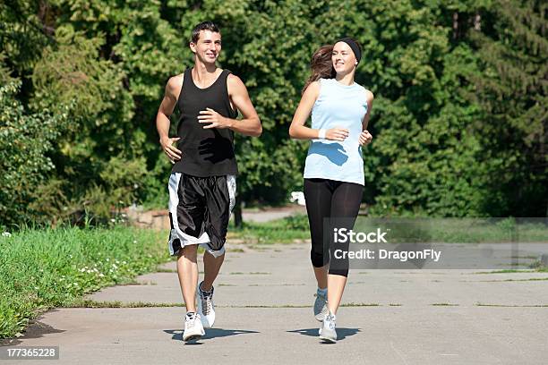 Photo libre de droit de Couple Sportif Jogging Dans Le Parc banque d'images et plus d'images libres de droit de Activité - Activité, Adolescence, Adulte