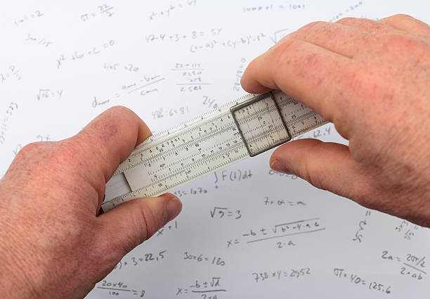 person calculating on a slide rule stock photo