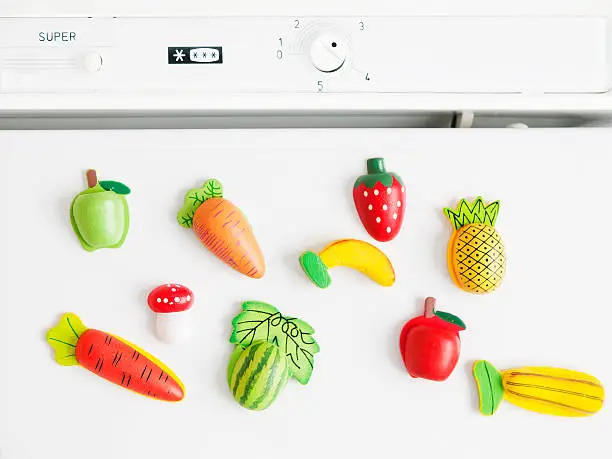 collection of magnets fridge in the form of fruit and vegetables placed on refrigerator door
