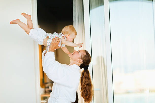 istock Mother in bathrobe playing with baby on terrace 177366071