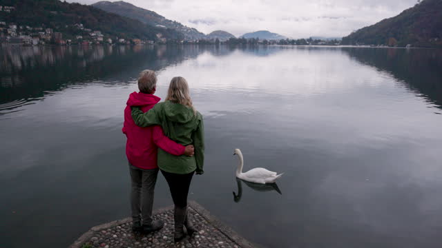 Mature couple enjoy bird life on tranquil lake
