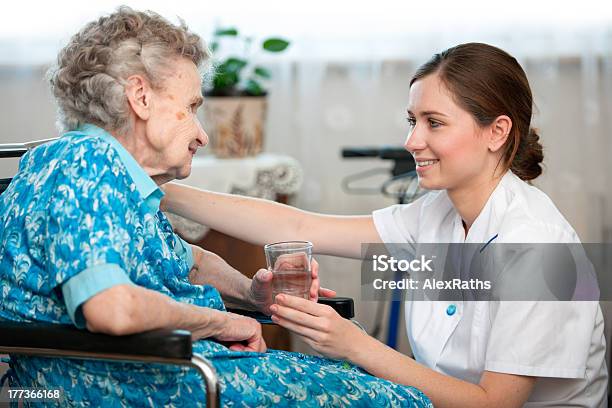 Nurse Handing Glass Of Water To Older Patient Stock Photo - Download Image Now - 80-89 Years, A Helping Hand, Adult