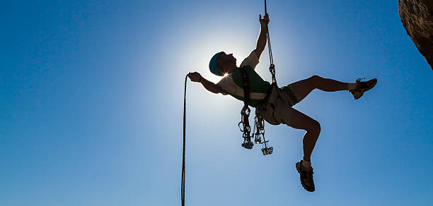 Climber rappelling from the summit. stock photo