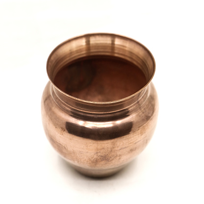 an old, vintage, empty copper pot vessel used for serving drinks and food in kitchen isolated in a white background