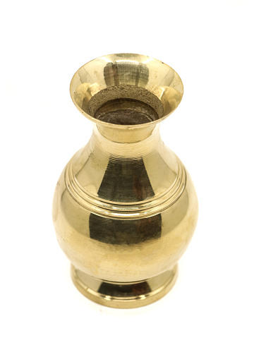 a plain vintage vase handcrafted with simple design in golden brass isolated in a white background