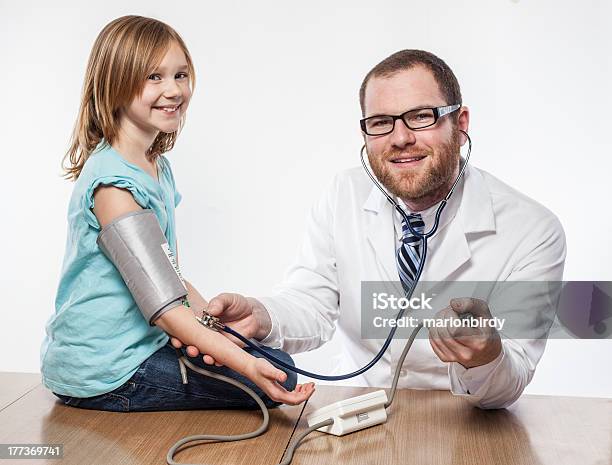 Jovem Macho Médico Lhe Dá Um Exame Físico Para Loura Engraçada Criança - Fotografias de stock e mais imagens de Assistência