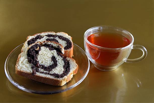 slices  poppy-seed cake and cup of tea stock photo