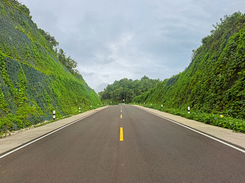 Asphalt Road. Landscape Road With A Perfect Asphalt In The Afternoon. Green Karst Cliff, Cloudy Sky. Panoramic. Travel Background. Highway With Hills