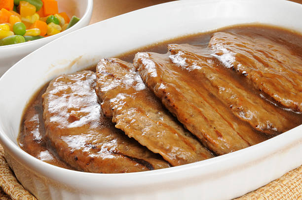 Serving dish of salisbury steak Close up of a serving dish with salisbury steak smothered in gravy salisbury steak stock pictures, royalty-free photos & images