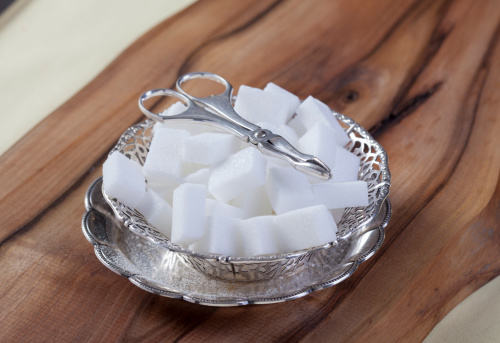 White Sugar Cubes in silver  bowl with silver tongs