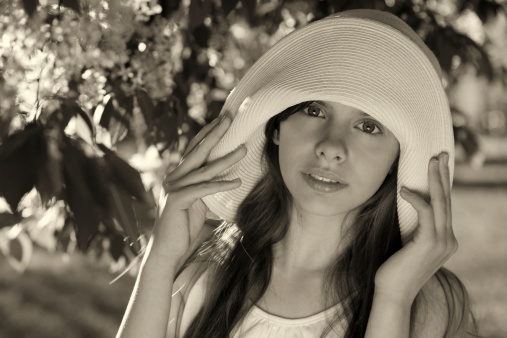 Summer portrait of a little girl wearing a large hat