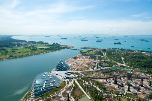 A wide perspective view of ships moored and botanical garden from the roof top of Marina Bay Sand Hotel in Singapore