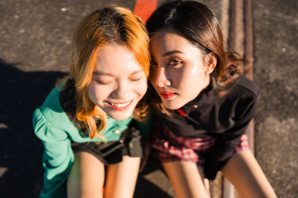 Two cheerful female friends are taking selfies while sitting in front of a Cathedral - Basílica de Santa María, Cathedral of Palma de Mallorca