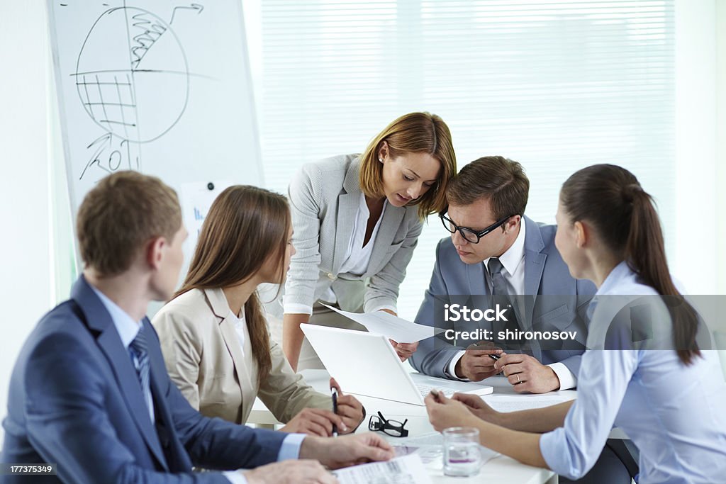 Men and women in a business meeting Image of confident partners discussing paper at meeting Adult Stock Photo