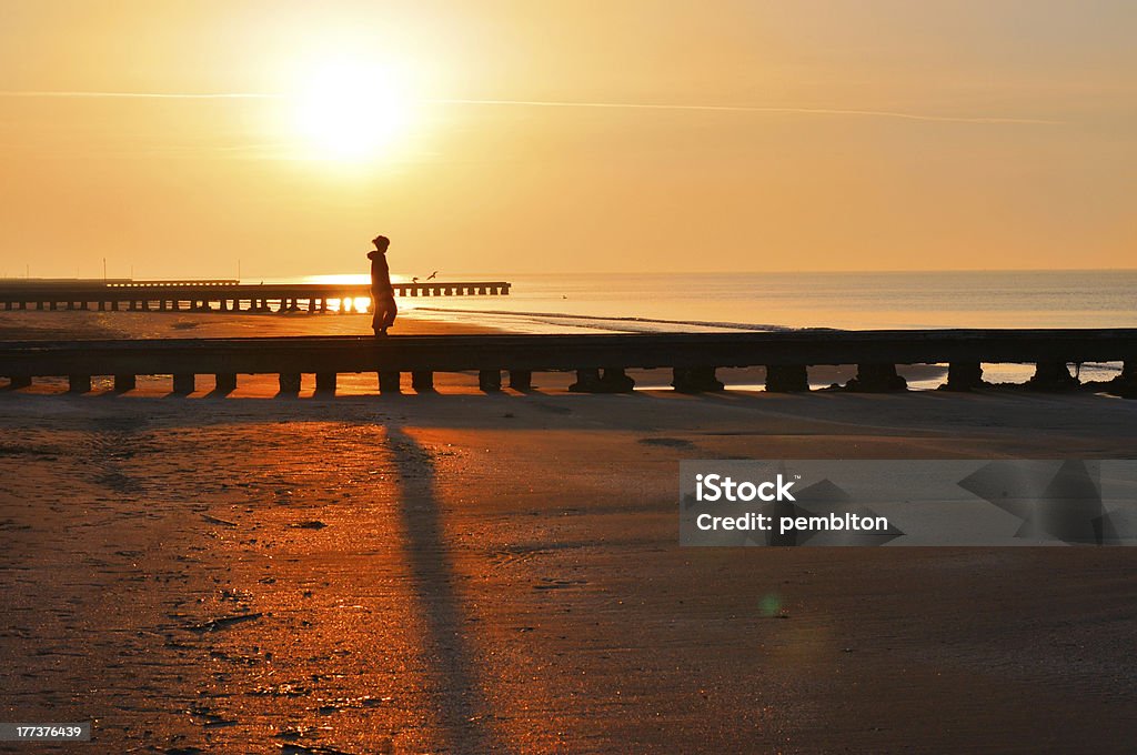 Mulher andando no cais no nascer do sol - Foto de stock de Adulto royalty-free