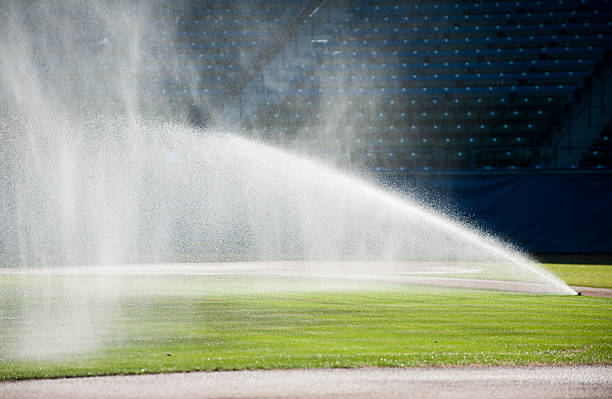 Sprinkler watering a baseball field.