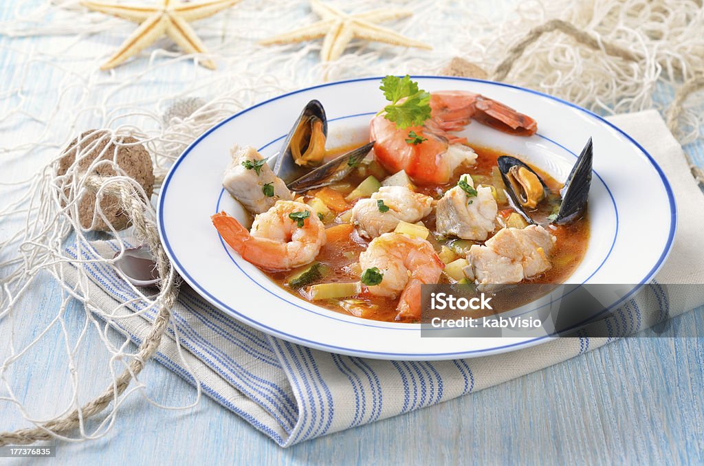 Delicious fish soup "Delicious fish soup with shimps, mussels, fish fillet and vegetables" Fishing Net Stock Photo