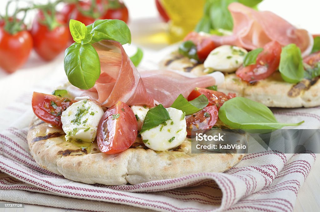 Pita bread with salad "Pita bread with delicious Italian ham, cherry tomatoes, mini-mozzarella and basil" Appetizer Stock Photo