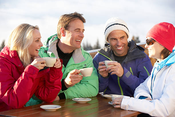 freunde genießen sie warme getränke im café in ski resort - apres ski friendship skiing enjoyment stock-fotos und bilder