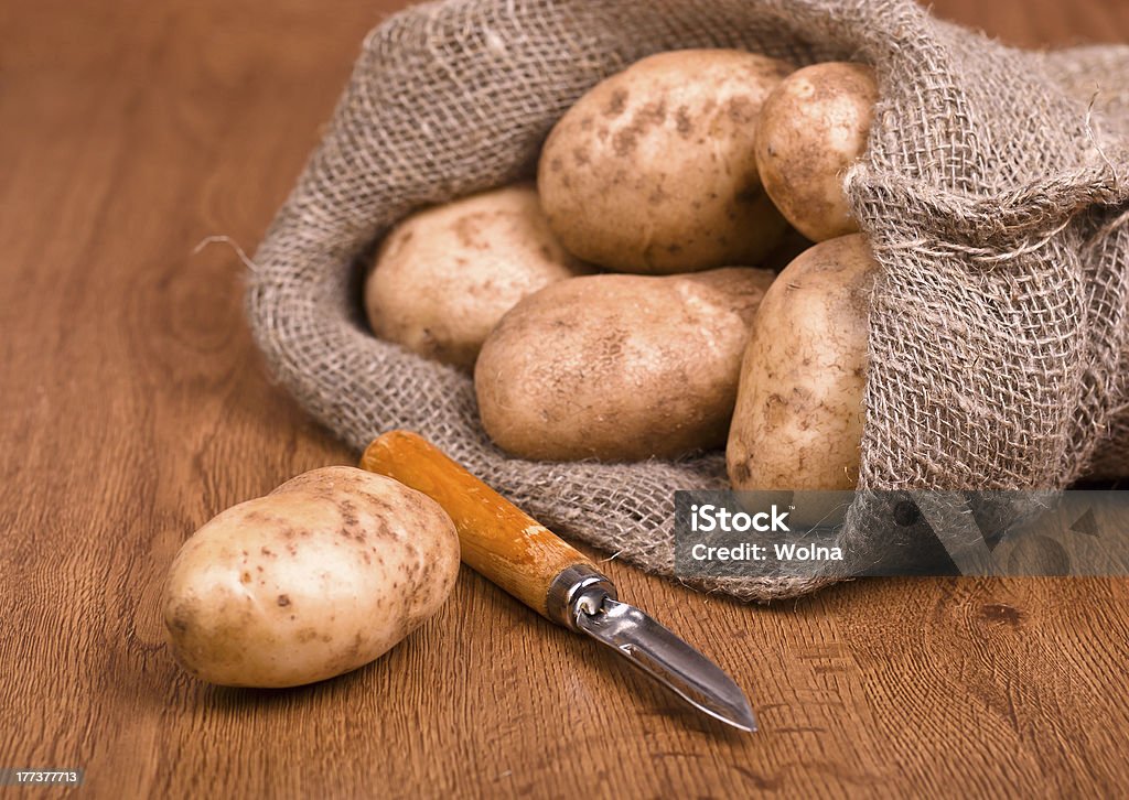 Batatas com faca para limpar os legumes - Foto de stock de Abundância royalty-free