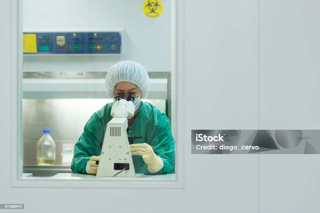 Mulher trabalhando com um Microscópio em biotecnologia laboratório - Foto de stock de Adulto royalty-free