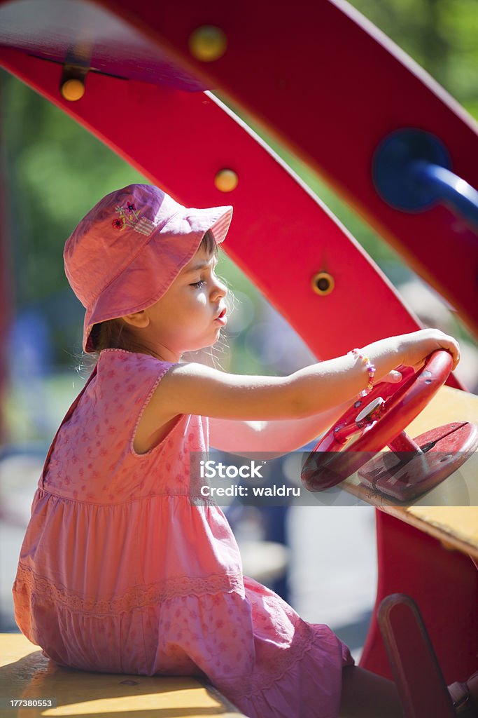 Little driver Cute little girl driving a toy-car on a playground in the park 4-5 Years Stock Photo
