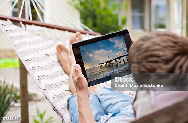 Man Using Tablet Computer While Relaxing In A Hammock Stock Photo - Download Image Now