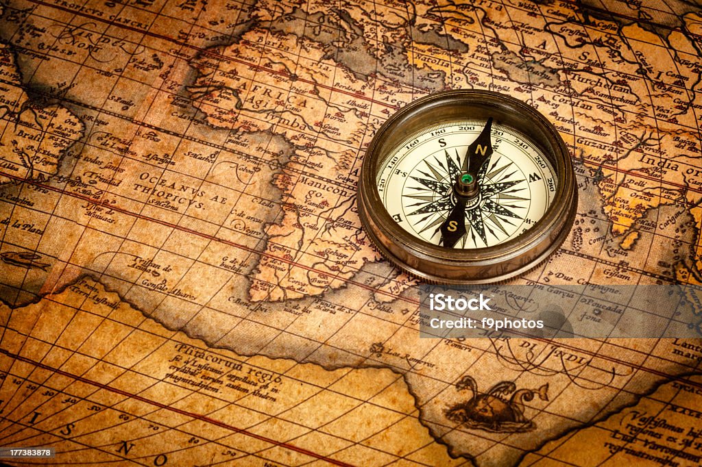 Old vintage compass on ancient map Old vintage retro compass on ancient map.  Navigational Compass Stock Photo