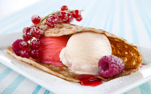 pancake with ice cream red berries and strawberry syrup