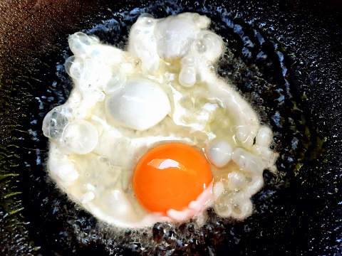 Cooking fried egg - food preparation.
