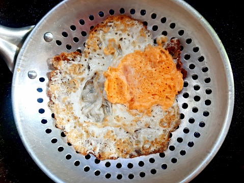 Cooking fried egg - food preparation.