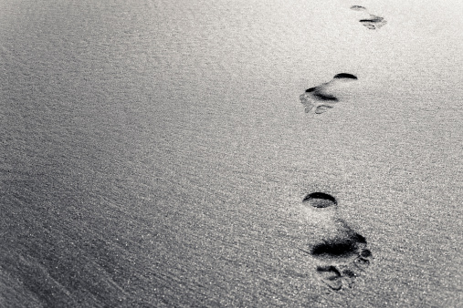 Footprints cross the sands. Colour toned.