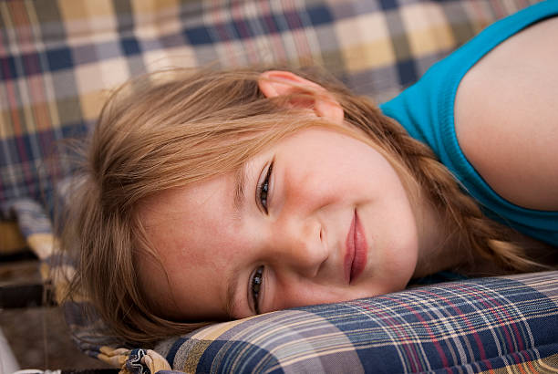 little girl lying on a garden swing stock photo