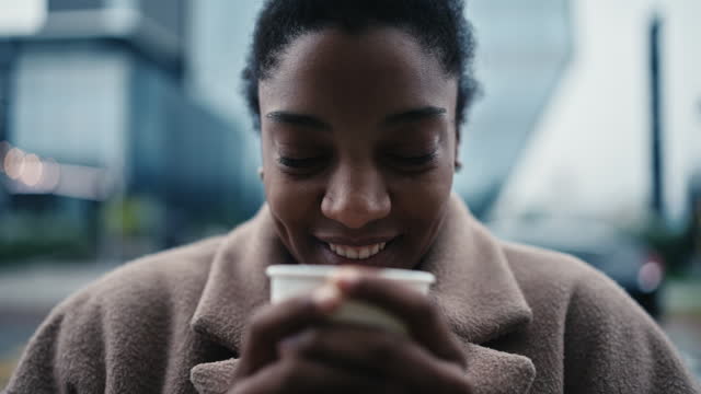 SLO MO Closeup Portrait of Smiling Young Woman Blowing Air on Cup of Coffee in City