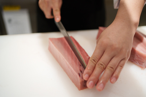 close up of slicing red meat on a wooden chopping board. suitable for meat and food theme.