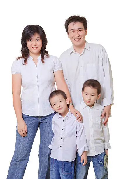 "Young Asian Family, mother, father and two sons. All wearing jeans and white shirts on a isolated white background."