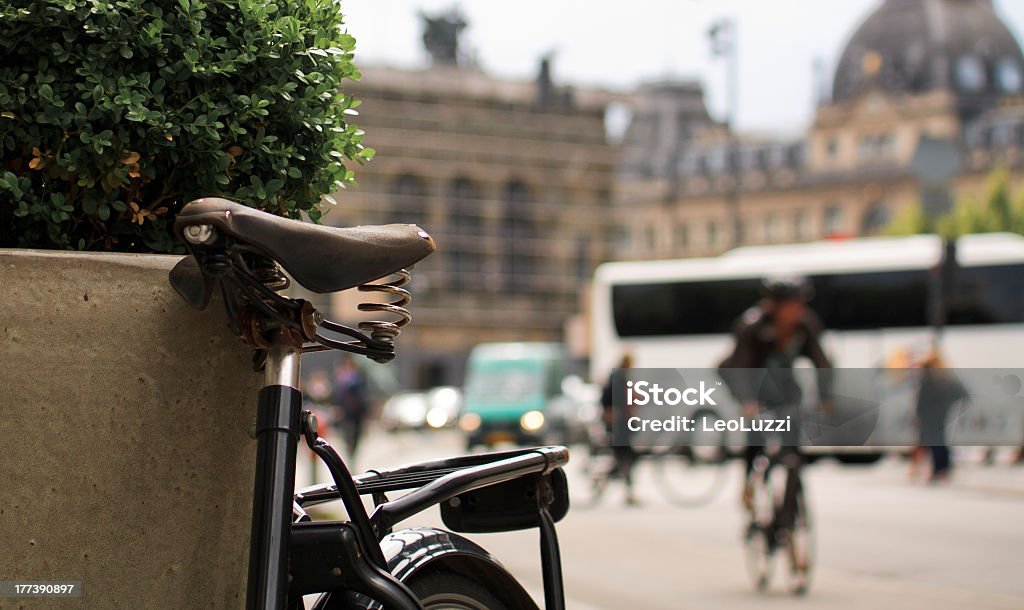 Bicycle saddle at Downtown Copenhagen Detail of bicycle saddle at downtown Copenhagen while commuter is passing by on a bicycle. Commuter Stock Photo