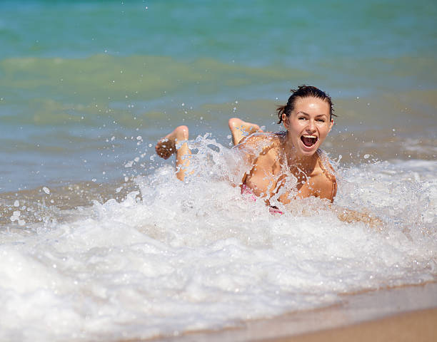 Young woman lying in foam of sea