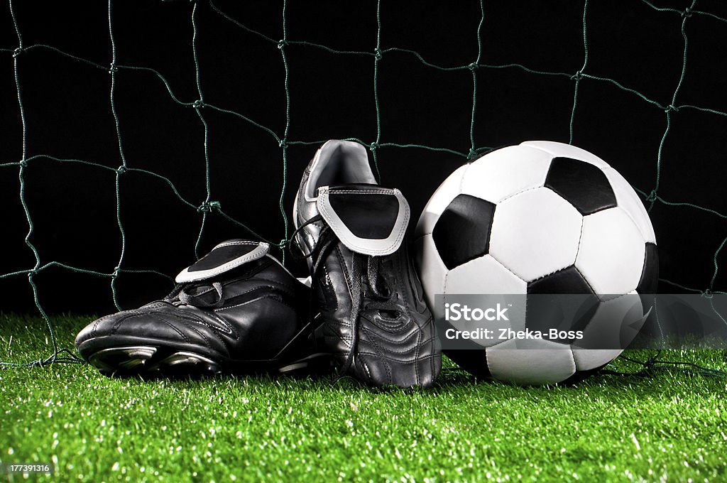 soccer ball and cleats soccer ball and cleats on the football field Boot Stock Photo