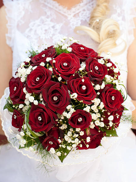 Vase of fresh red roses at the bright window