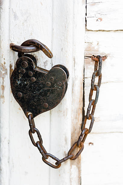 istock Lock and chain on weathered white door 177392722