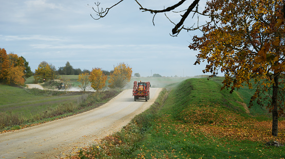 Rural landscape with two tractors on a gravel road.