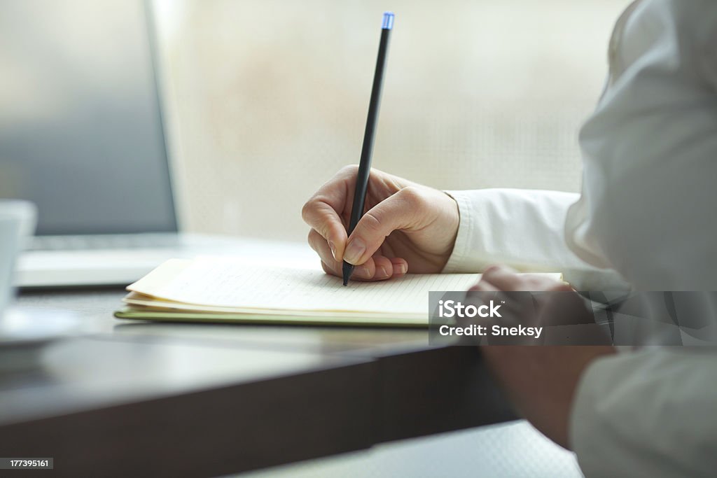Business woman Young businesswoman making some notes in notebook. Adult Stock Photo